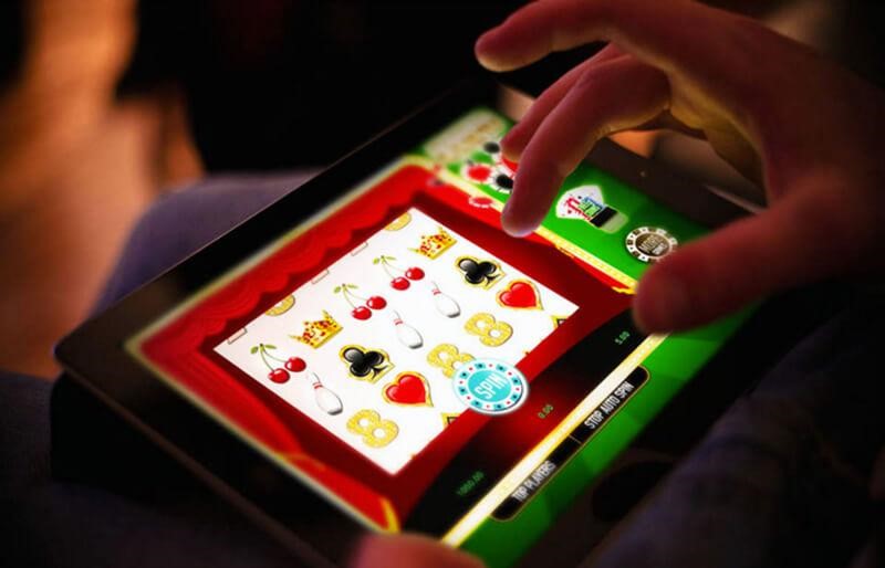 Top 5 Slot Providers: A More Focused Ranking 1 Person playing an online slot game on a tablet, spinning reels with classic symbols
